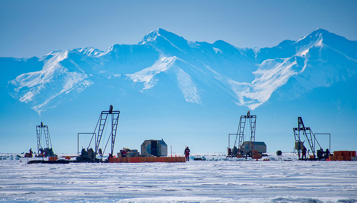 Развертывание нейтринного телескопа Baikal-GVD с ледового покрова озера во время экспедиции на озеро Байкал. В кадре несколько спуско-подъемных устройств и бригад, погружающих элементы телескопа на глубину озера, на фоне хребта на противоположной стороне озера