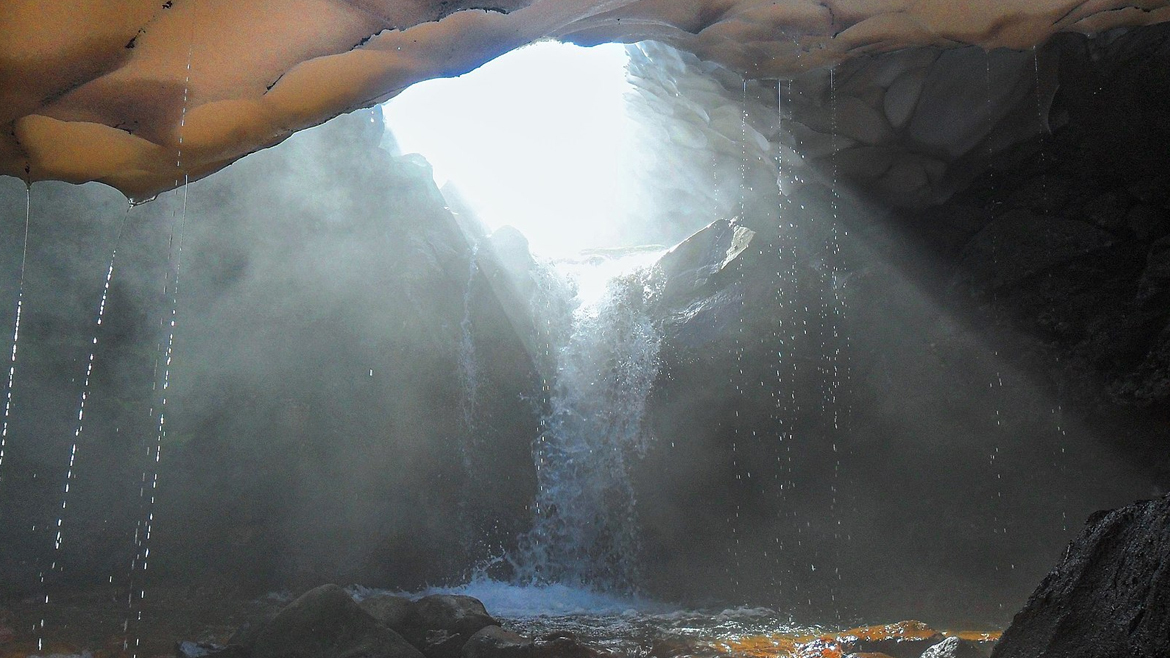 Снежная пещера, образовавшаяся над ручьём от таяния снега и вымыта талыми водами вместе с небольшим водопадом
