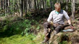 Виктор Миронов проводит измерение роста сфагнума в полевых условиях