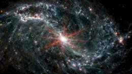 Галактика NGC 7496. Нити и полости показывают, как молодые звезды выделяют энергию, а в некоторых случаях смещают газ и пыль из окружающей их межзвездной среды. В центре - сверхмассивная черная дыра